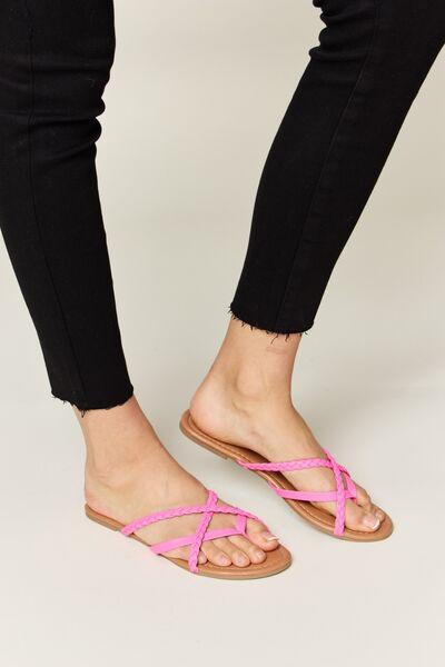 a woman's feet wearing sandals and black pants