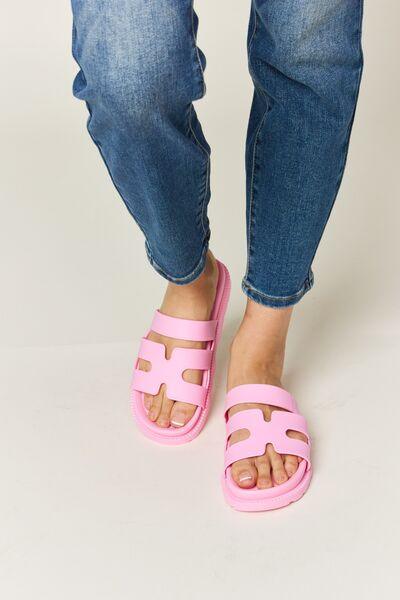 a woman wearing pink sandals and jeans