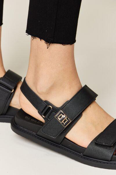 a close up of a person wearing black sandals