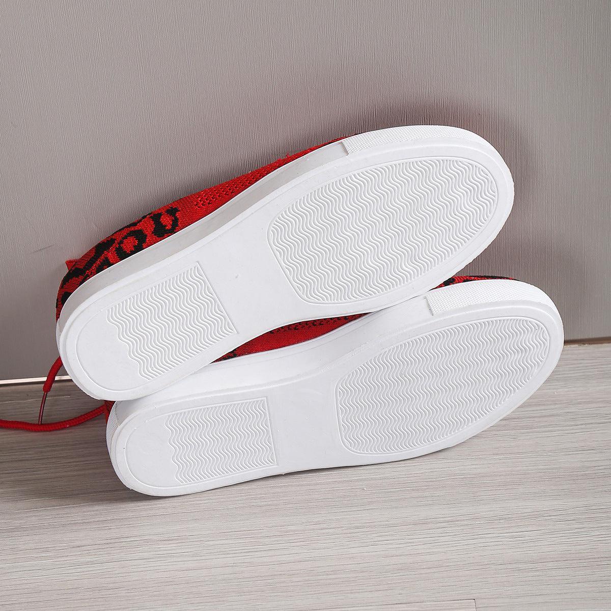 a pair of white and red shoes sitting on top of a wooden floor