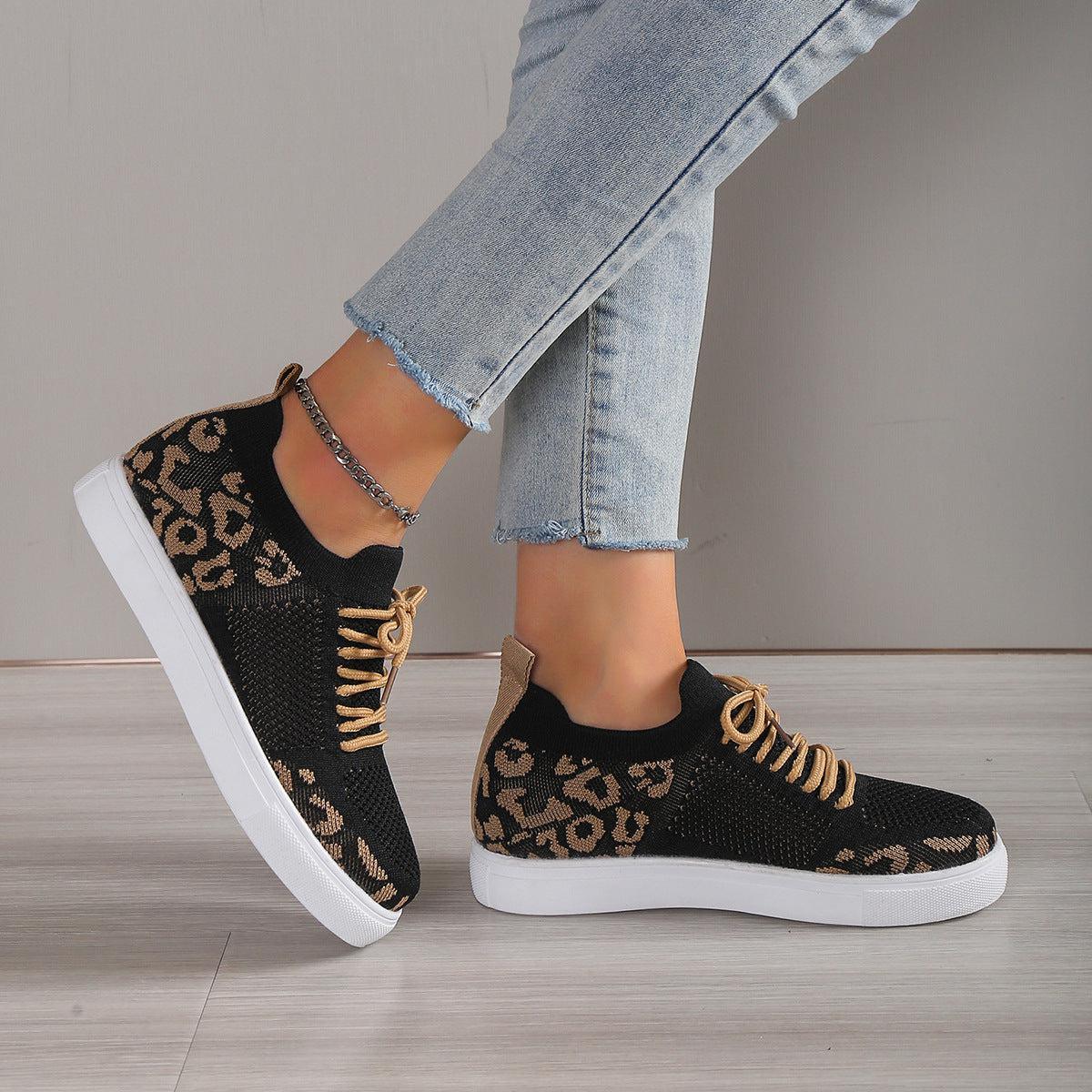 a woman's feet wearing leopard print sneakers