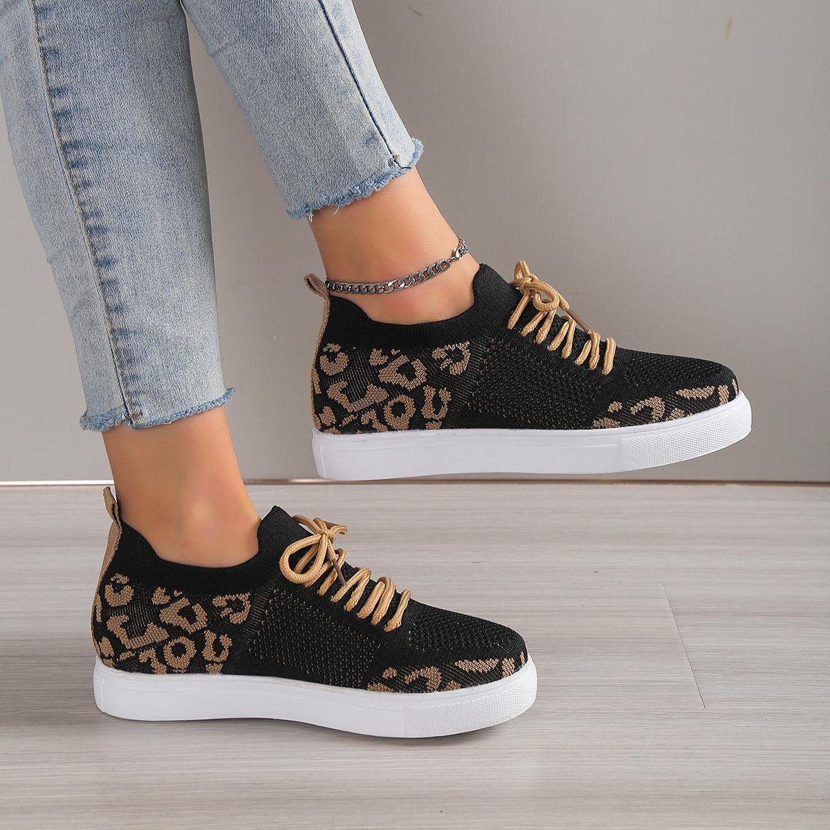a woman's feet wearing leopard print sneakers