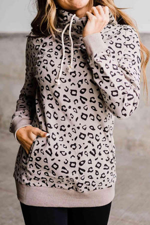 a woman wearing a leopard print hoodie and black leggings