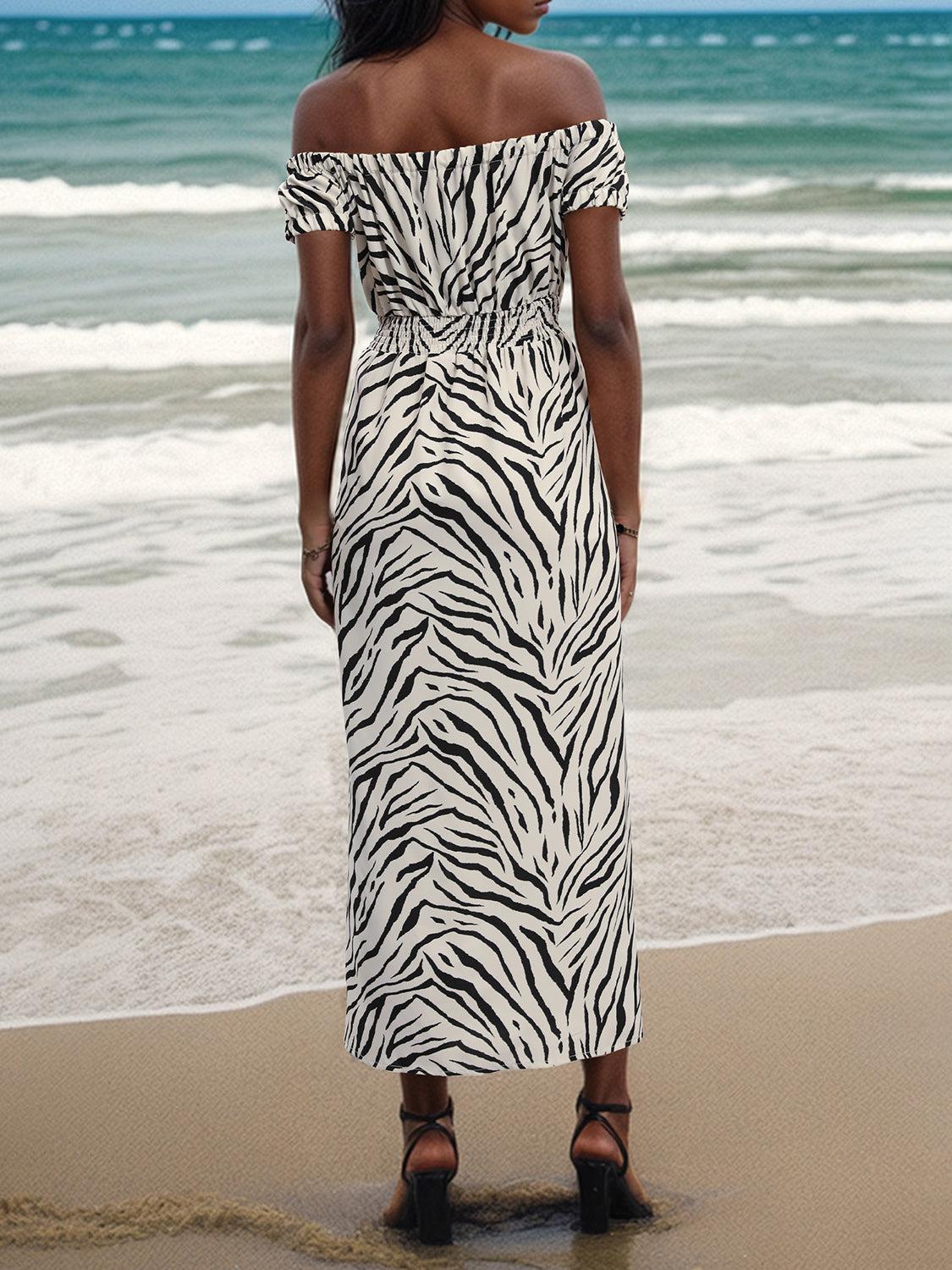 a woman in a zebra print dress standing on the beach