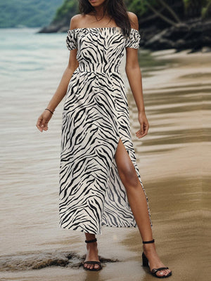 a woman in a zebra print dress standing on a beach