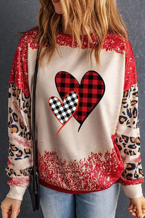 a woman wearing a red and black heart sweatshirt