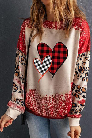 a woman wearing a red and black heart sweater