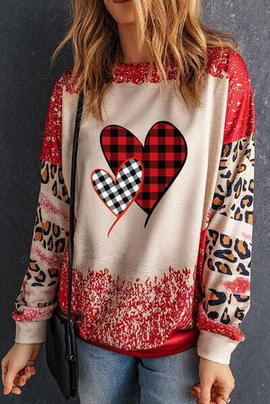 a woman wearing a sweater with a heart on it