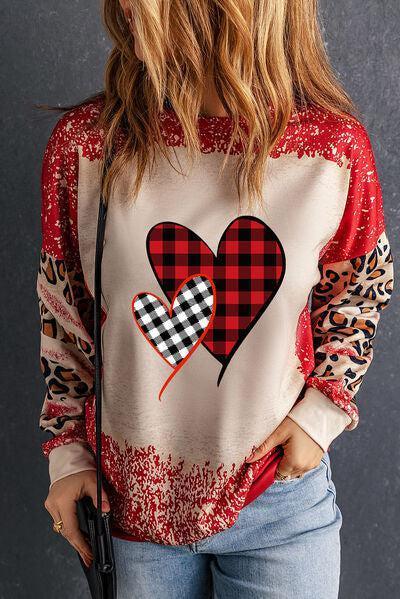 a woman wearing a red and black heart sweater