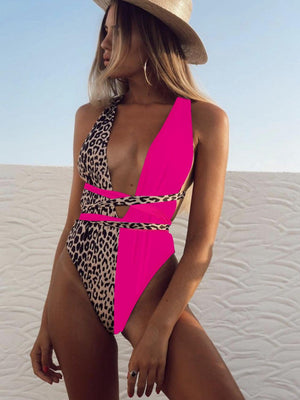 a woman in a pink and leopard print one piece swimsuit