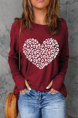 a woman wearing a red shirt with a white heart on it