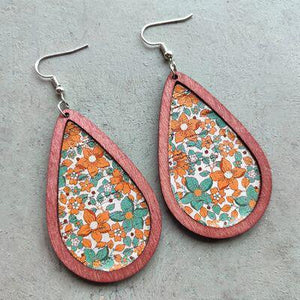 a pair of earrings with a floral design