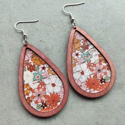 a pair of wooden earrings with floral designs