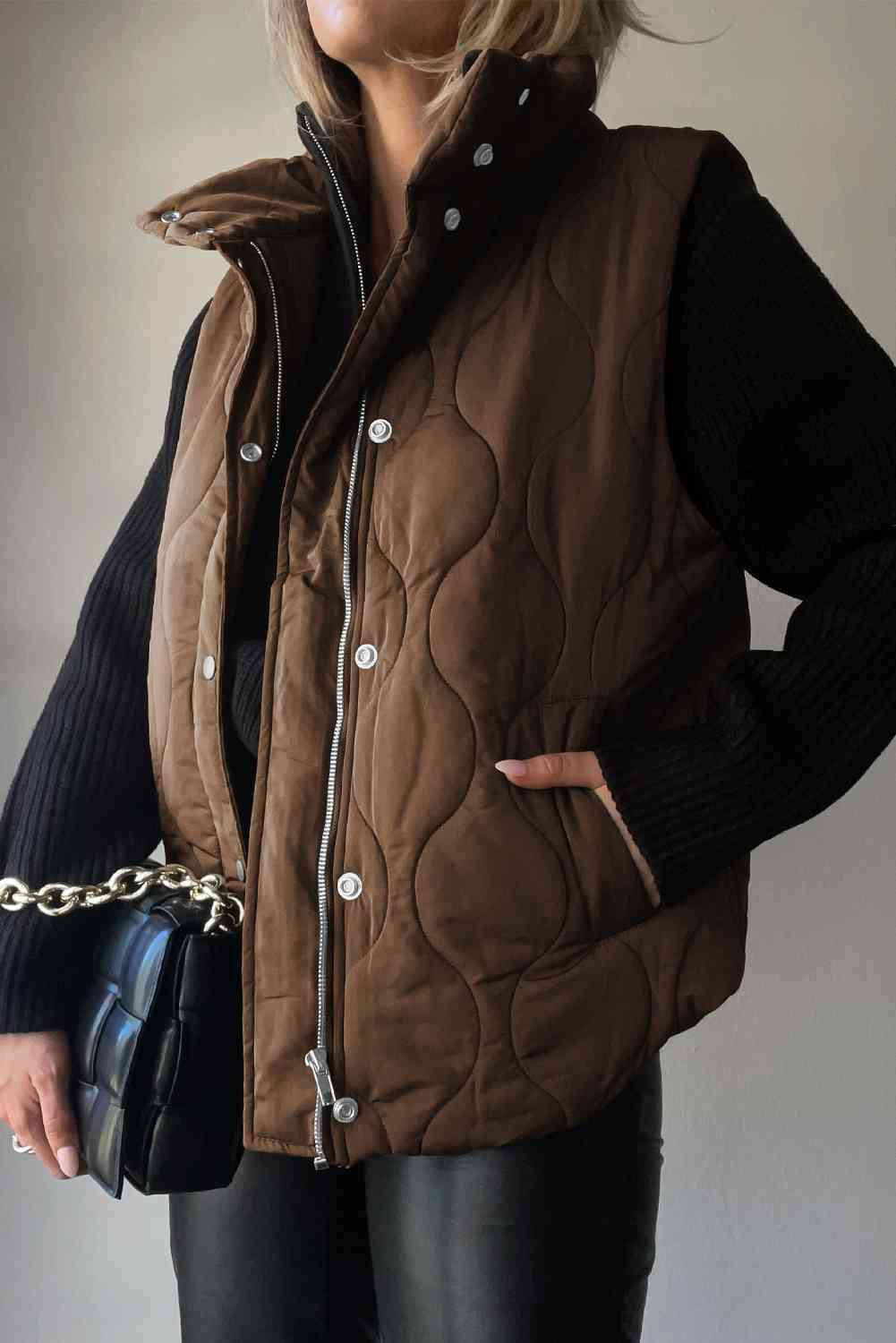 a woman wearing a brown quilted vest and black pants