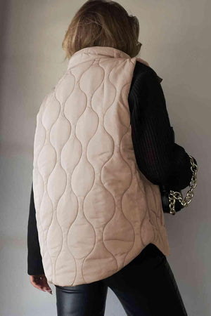 a woman wearing a beige quilted leather vest