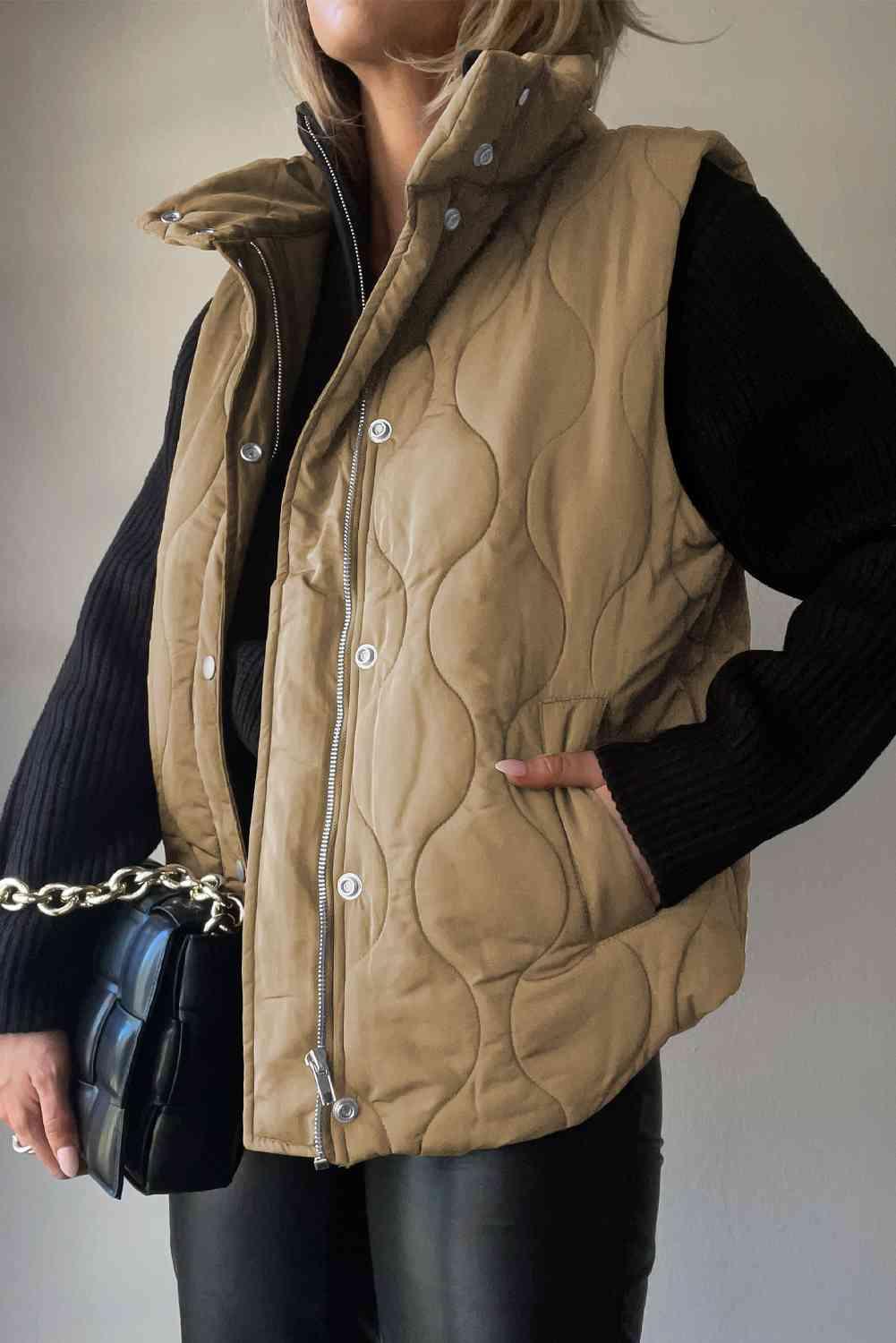 a woman wearing a tan quilted vest and black pants