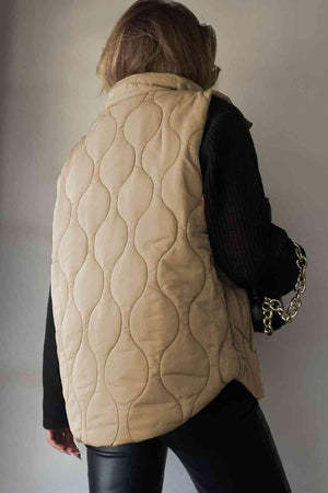 a woman wearing a beige quilted vest
