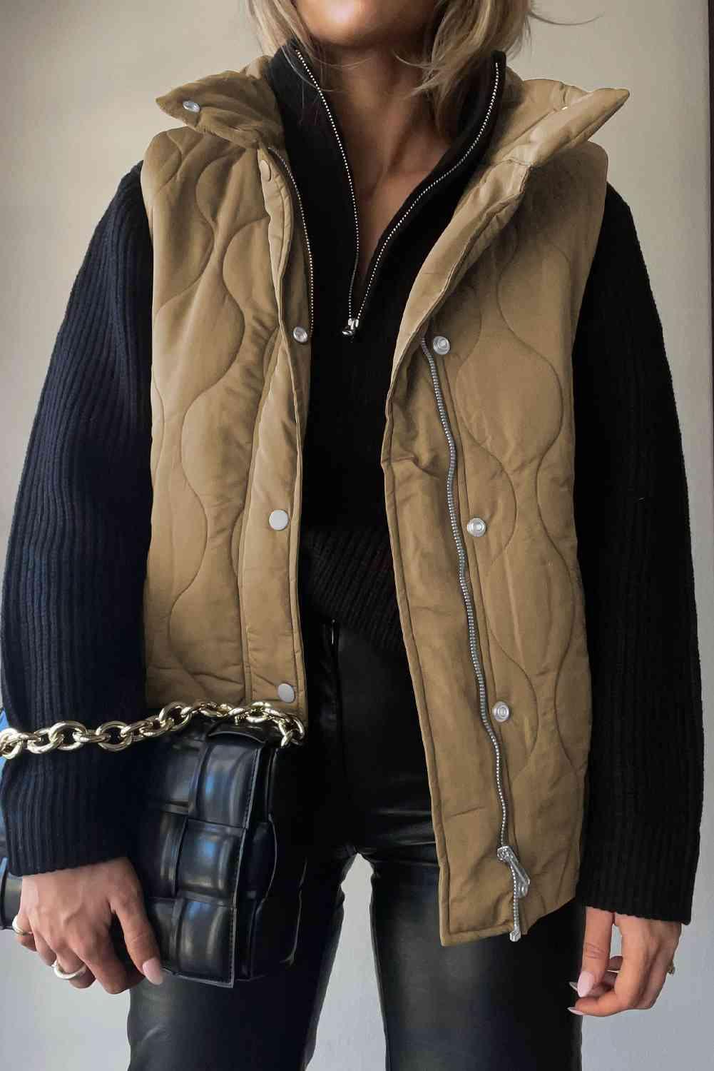 a woman wearing a brown quilted vest and black leather pants