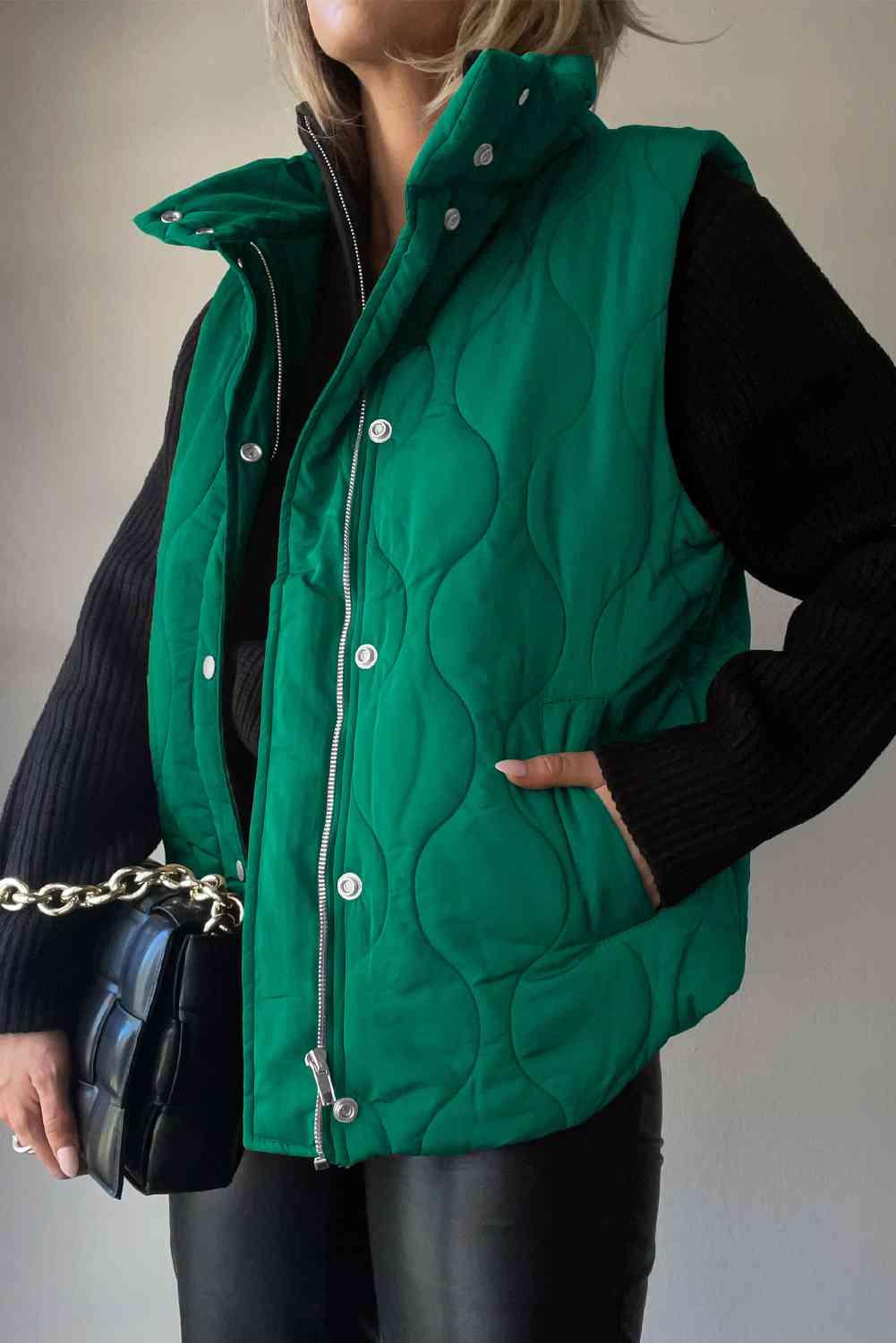 a woman in a green vest holding a black purse