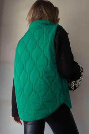 a woman wearing a green quilted vest