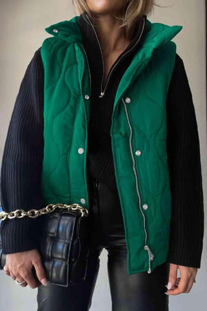 a woman wearing a green jacket and black pants