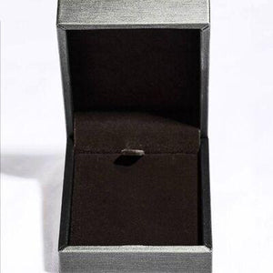 a ring in a box on a white surface