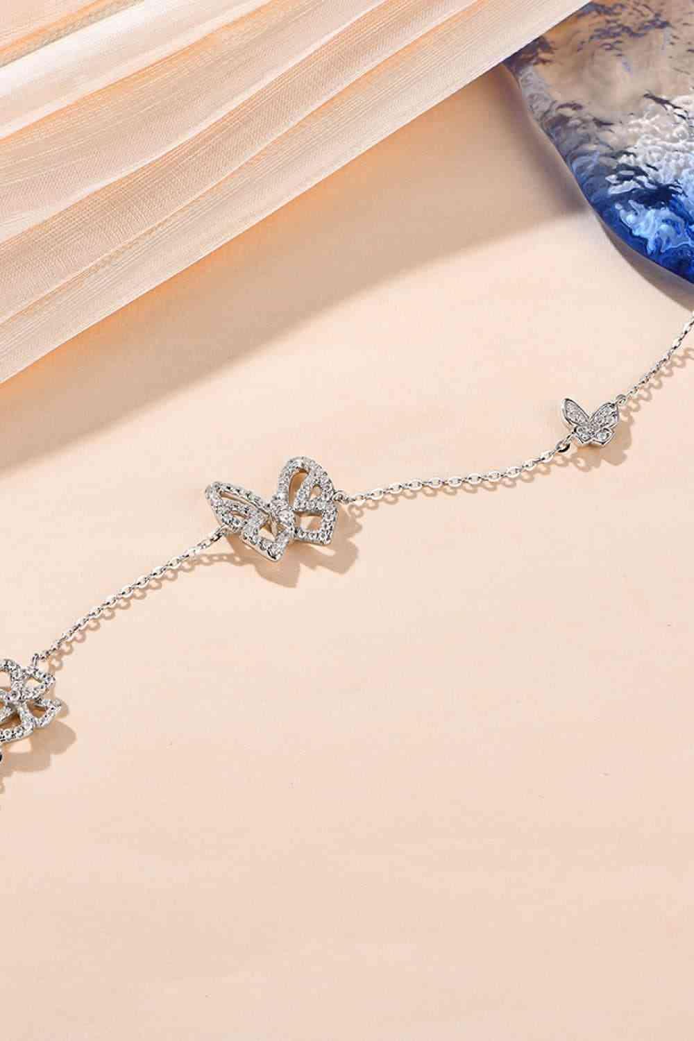a close up of a necklace with butterflies on it