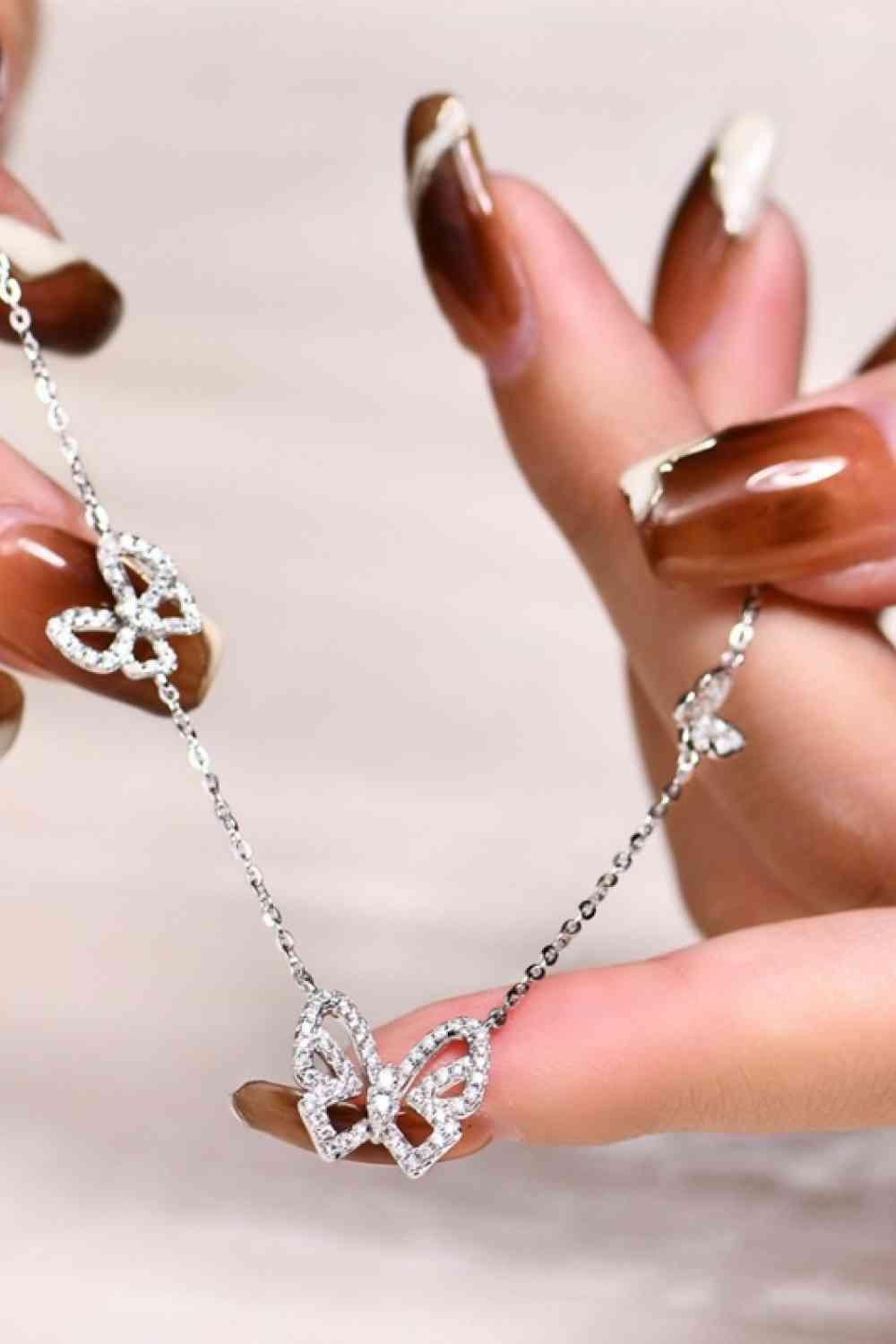 a woman's hand holding a diamond necklace