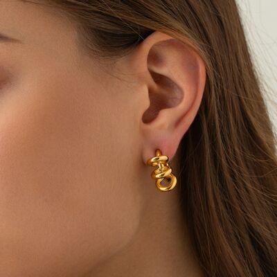 a woman wearing a pair of gold earrings