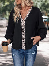 a woman holding a cup of coffee and wearing a black top