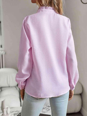 a woman wearing a pink sweater and jeans