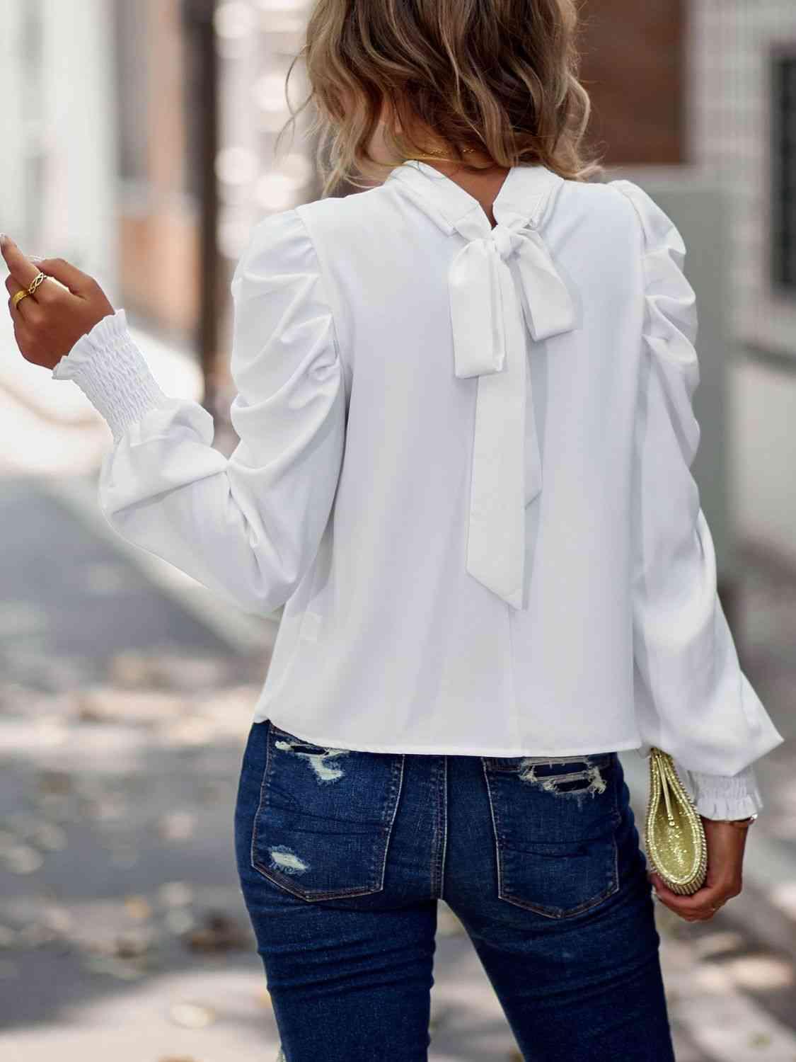 a woman wearing a white blouse and jeans