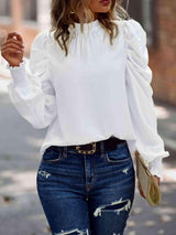 a woman wearing ripped jeans and a white blouse