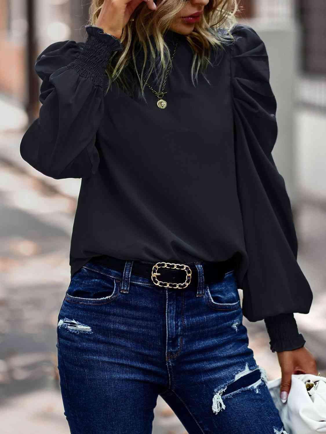 a woman wearing a black top and ripped jeans