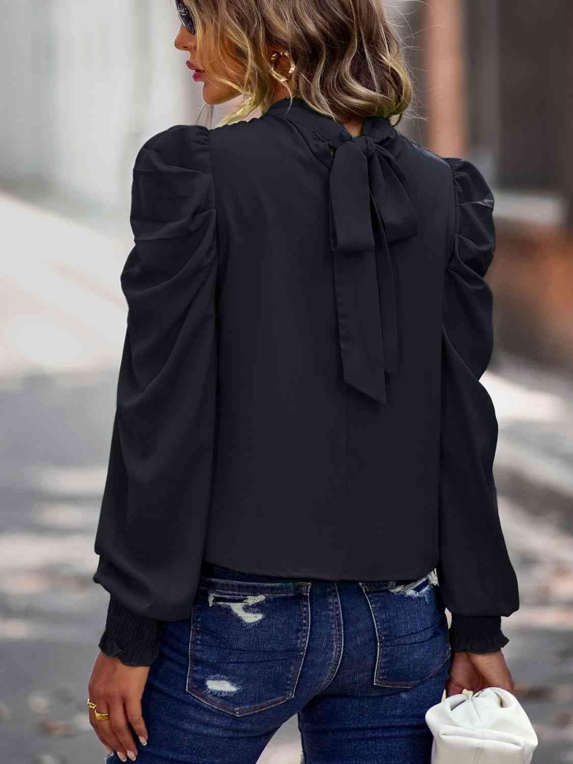 a woman wearing a black blouse and jeans