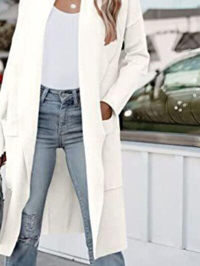 a woman wearing a white coat and jeans