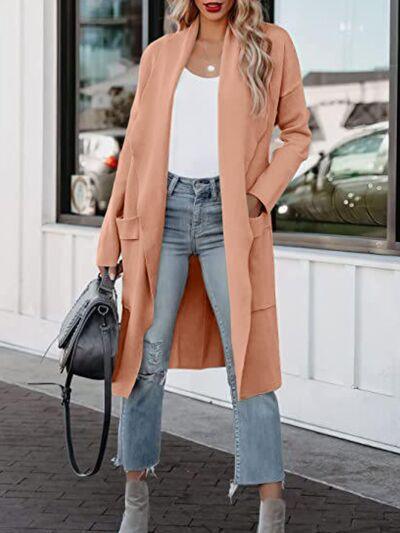 a woman standing outside of a building wearing a long coat