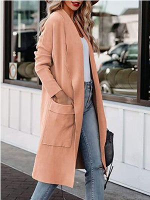 a woman wearing a tan coat and jeans