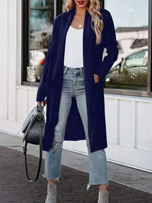 a woman wearing a long blue coat and jeans