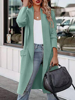 a woman wearing a green coat and jeans