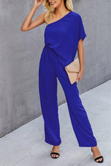 a woman in a blue jumpsuit posing for a picture