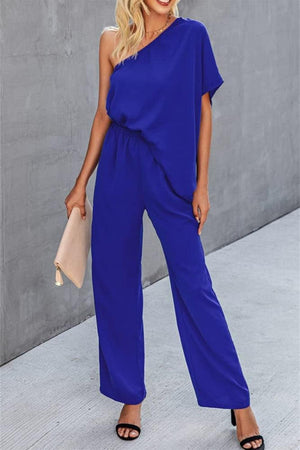 a woman wearing a blue one shoulder jumpsuit