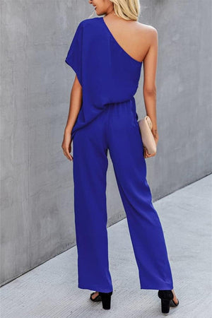 a woman in a blue one shoulder jumpsuit