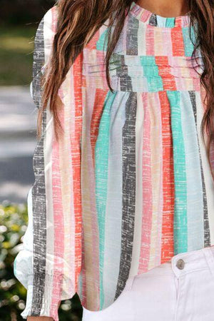 a woman wearing a colorful shirt and white jeans