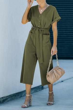 a woman in a green jumpsuit talking on a cell phone