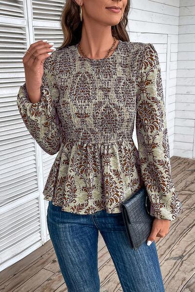 a woman standing on a porch wearing jeans and a blouse