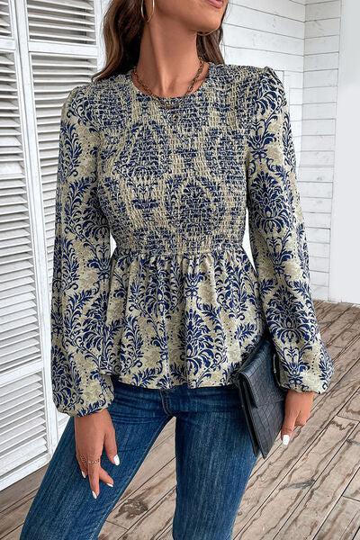 a woman standing on a porch wearing a blue and white top