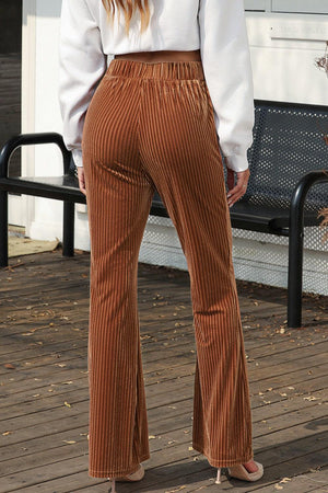 a woman in a white shirt and brown pants