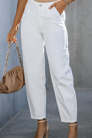 a woman in white pants and heels holding a purse