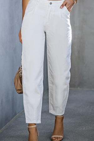 a woman is wearing white pants and heels